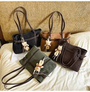 Close-up of four vintage tote bags in black, brown, green and coffee with cute bear charms