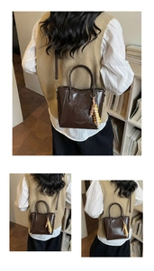 Detail einer dunkelbraunen Lackleder-Beuteltasche mit elegantem Perlenanhänger