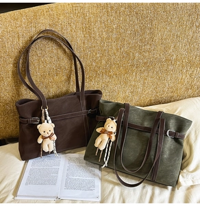 Detail of vintage tote bags in coffee brown and olive green with cute plush bear charms