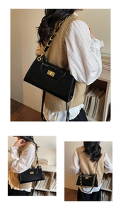 Detail of black glossy patent leather shoulder bag with golden chain and metal clasp