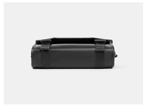 Detail shot of black crossbody bag with matte synthetic leather and buckle straps