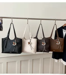 Detail of four colorful tote bags with horse charms hanging on a rack for office commute