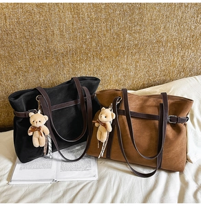Detail of matte faux leather tote bags in black and brown with plush bear charms