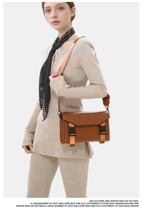 Close-up of vintage brown messenger bag with durable oxford fabric and dual buckle straps