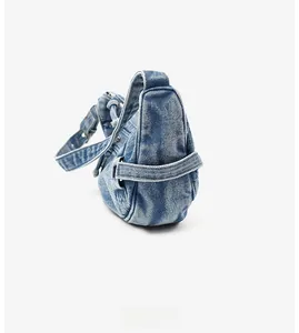 Détail latéral du sac lune en denim bleu délavé vintage avec bandoulière réglable