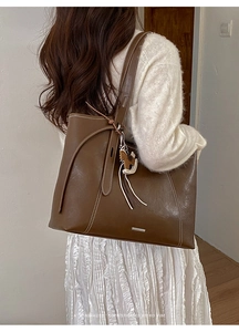Brown retro tote bag with white stitching and leather horse charm shown on model