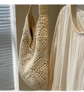 Detailed close-up of beige crochet hobo bag with geometric openwork texture and fabric lining
