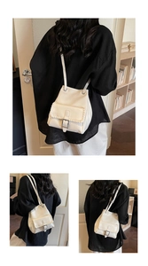 Detail of white bucket backpack showing woven stitching and silver buckle accent