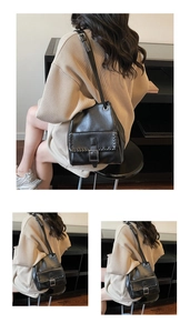 Detail of black leather bucket bag featuring silver buckle and woven stitching accents