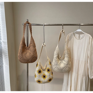 Detail of three handmade crochet straw tote bags with floral patterns and woven texture