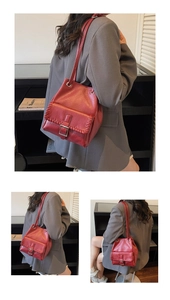 Detail of red bucket bag with woven stitching and metal buckle on adjustable strap