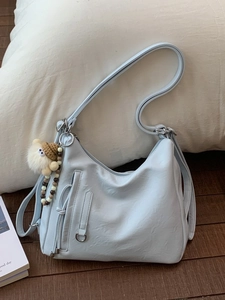 Light blue faux leather crossbody bag with a cute plush doll charm and zipper detail