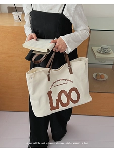 Détail du sac cabas en toile montrant l'imprimé vintage et l'anse en cuir marron