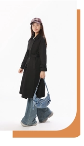 Vue d'ensemble d'un sac bandoulière en denim en croissant avec un trench-coat noir