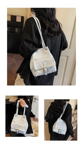 Detail of white bucket bag with braided stitching and silver metal buckle decoration