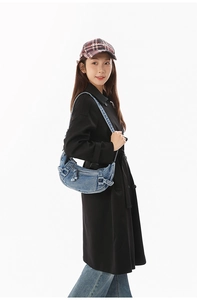 Gros plan d'un sac demi-lune en jean délavé bleu avec détails de boucles de ceinture