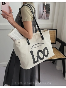Détail d'un grand sac cabas en toile avec imprimé lettres et bandoulières noires chic