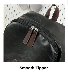 Detail of smooth double zipper with brown leather pulls on black textured backpack