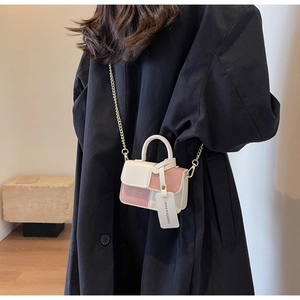 Details der farblich abgesetzten Mini-Handtasche mit Kette und modischem Anhänger