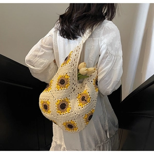 Detail of hand-woven straw tote bag with vibrant sunflower crochet patterns and large capacity