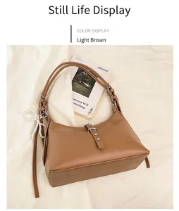 Detail of light brown faux leather dumpling bag with pearl charm and metal buckle