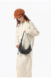 Modèle portant un sac demi-lune en denim noir vintage avec bandoulière et détails zippés