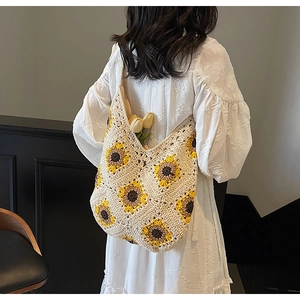 Detail of hand-crocheted shoulder bag with 3D sunflowers on ivory cotton weave