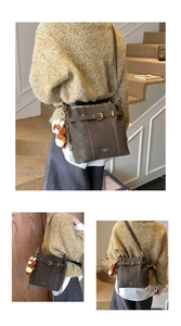 Detail der braunen Vintage-Beuteltasche mit Gold-Schnalle und Teddybär-Anhänger