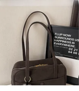 Detailed macro view of retro brown matte tote bag with golden zipper and plush pendant