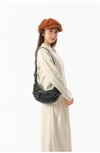 Détail d'un sac vintage noir avec des poches fonctionnelles et des boucles argentées