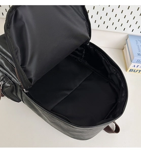 Spacious interior of black PU leather backpack with nylon lining and inner pocket