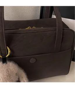 Detail view of brown faux suede tote bag with front pocket and plush rabbit charm