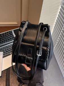 Sac seau minimaliste en cuir noir avec bordure tressée et longue bandoulière réglable