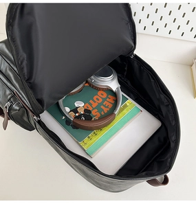 Large capacity black leather backpack shown open with laptop and daily essentials