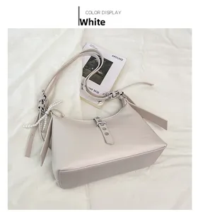 Close-up of cream white hobo bag with pearl strap detail and embossed logo