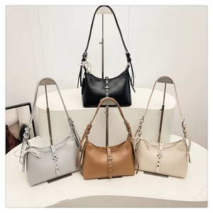 Detail view of stylish dumpling bags in four colors with rivet trim and pearl charms