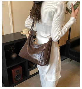 Détail du cabas vintage en cuir marron avec fermeture éclair et bandoulière