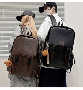 Detail view of vintage leather backpacks with side zip pockets and plush bear charms