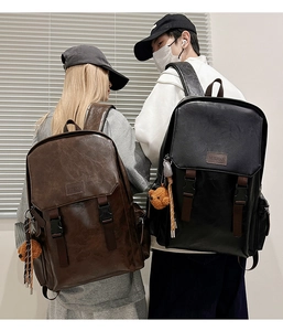 Rear view of leather backpacks in brown and black with bear pendants and buckles