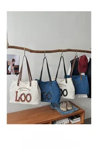 Κρεμαστές τσάντες tote από καμβά και denim με κείμενο Carry Your Joy Everywhere σε ζεστό χώρο