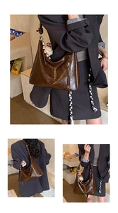 Détail du sac hobo marron foncé avec finition brillante et breloque ours mignon