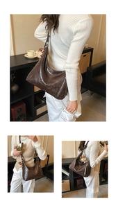 Détail du sac hobo marron foncé avec texture huilée et pendentif ours mignon