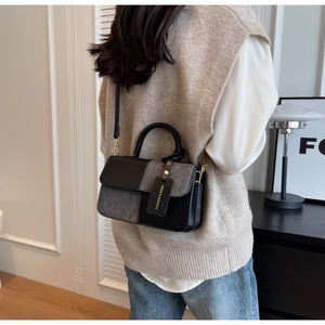 Fashionable color-block crossbody bag with leather and fabric texture shown on model