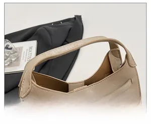 Detail of beige leather bucket bag featuring pleated texture and silver twist lock closure