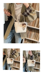 Detailed close-up of white lychee texture bucket bag with cute plush bear charm