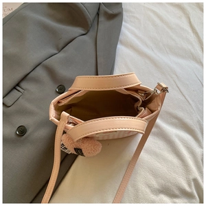 Sac seau à carreaux roses avec breloque cœur et bandoulière sur fond blanc