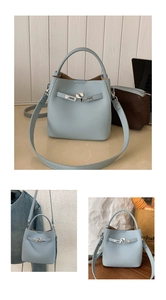 Detail of light blue lychee pattern leather bucket bag with metal twist lock and handle