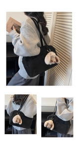 Detail of black tote bag featuring a cute plush bunny charm and textured suede finish