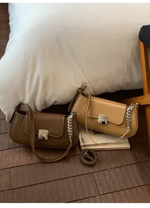Detail showing brown and camel minimalist leather bags with silver square metallic locks