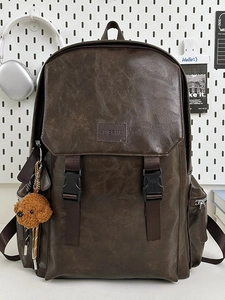 Retro dark brown pebbled faux leather backpack with twin buckle straps and plush charm